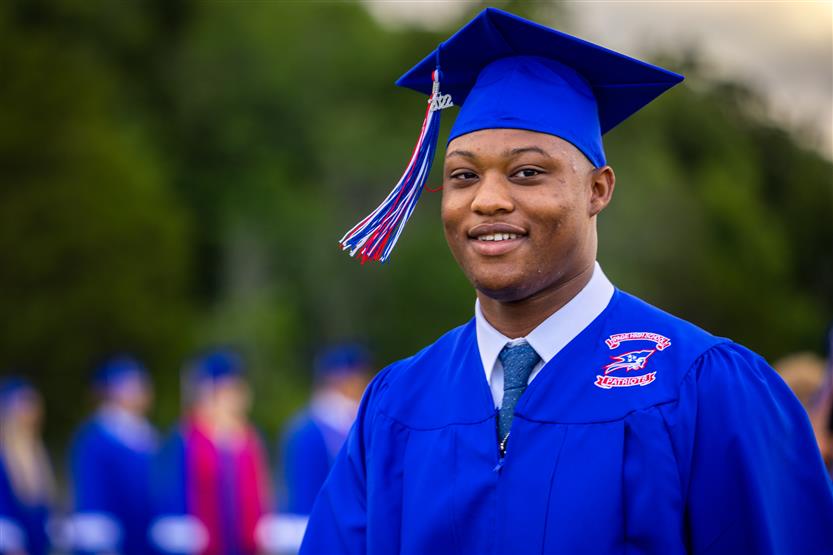 Students in blue robes graduate